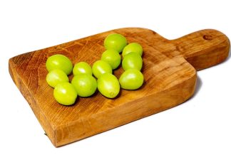 12 green grapes on a wooden serving board