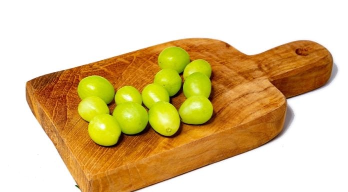 12 green grapes on a wooden serving board