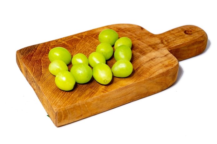 12 green grapes on a wooden serving board