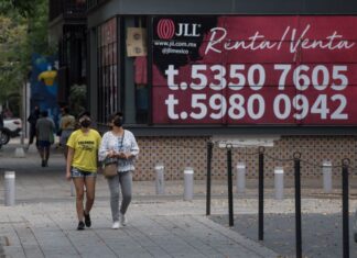 two people walkin gby a for rent sign
