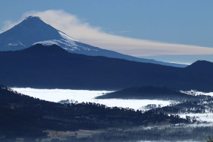 Breathtaking view of Popocatépetl and Iztaccíhuatl volcanoes covered in snow.