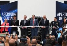 Mexican-government and Safran officials in a horizontal line preparing to cut a ribbon launching a new assembly line at Safran's aerospace parts manufacturing plant.