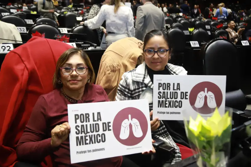 Two Mexican federal deputies holding up the same signs saying "Por la Salud de Mexico (For Mexico's health), in favor of a constitutional ban on the sale of vaping devices and e-cigarettes.