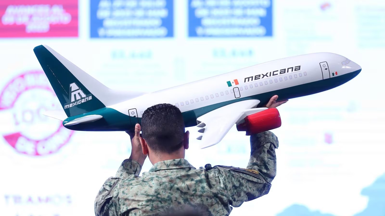 A member of Defensa carrying a Mexicana de Aviación plane model.