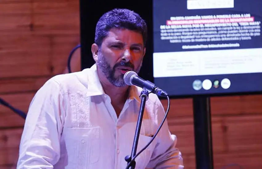 El activista ambiental mexicano José Urbina hablando en un evento frente a un micrófono