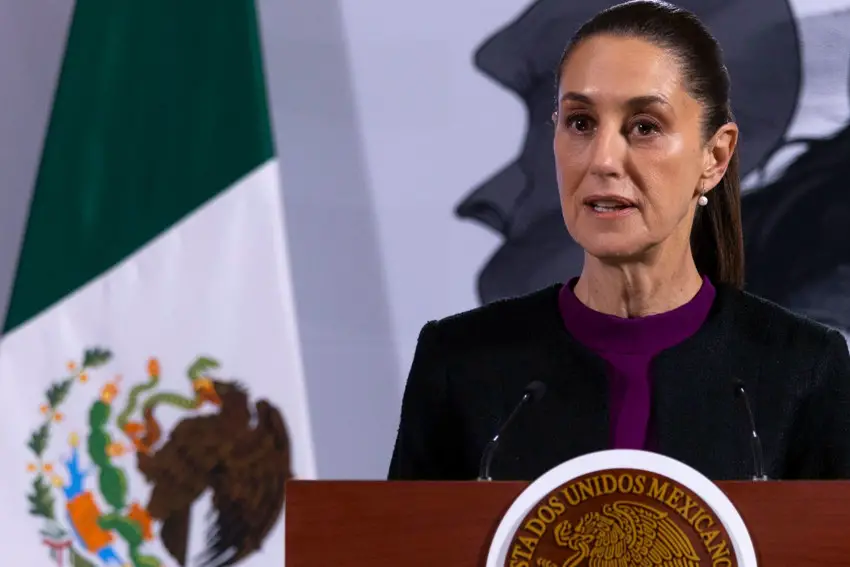 President Claudia Sheinbaum standing at a podium at her press conference