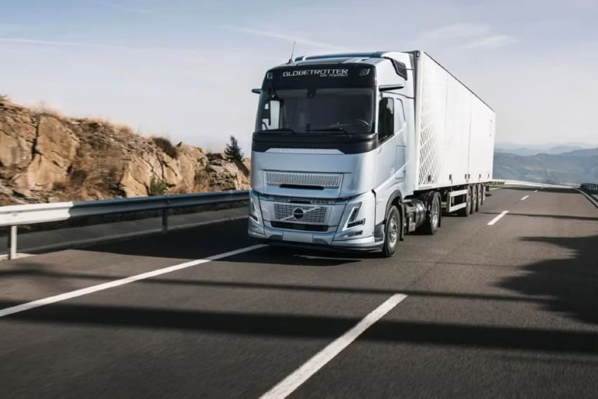 A silver Volvo semi trailer driving down an open highway