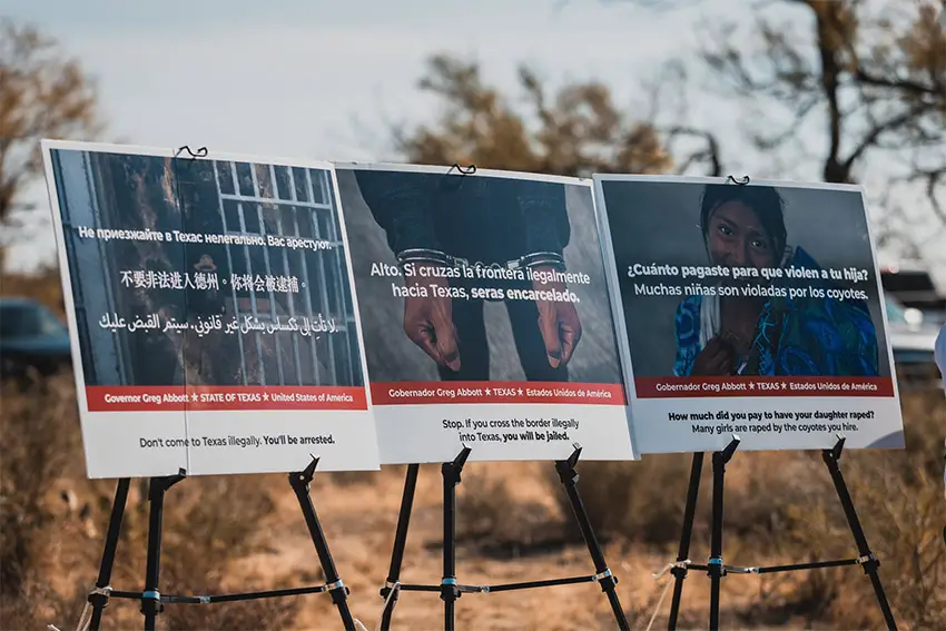 Posters set up in a desert display messages in various languages