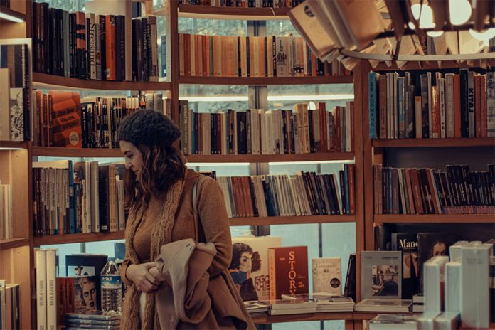 A woman browses books at a bookstore