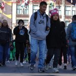 Mexico City residents in sweaters and warm hats walk through the city amid a cold front