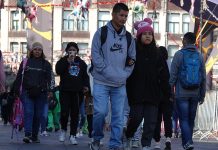 Mexico City residents in sweaters and warm hats walk through the city amid a cold front