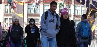 Mexico City residents in sweaters and warm hats walk through the city amid a cold front