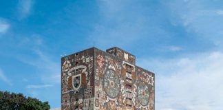 The National Autonomous University of Mexico library in Mexico City, a concrete building whose top floors is painted with the university logo and with a mural of images related to Mexico's indigenous history