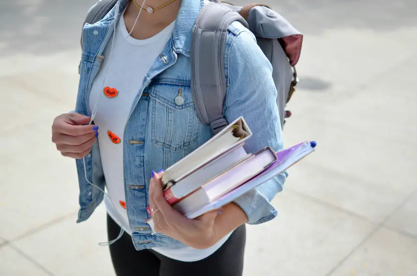 Una niña sosteniendo sus útiles escolares. 