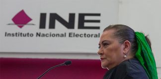 Mexico's elections chief Guadalupe Taddei stands in front of a sign reading "INE: Instituto Nacional Electoral"