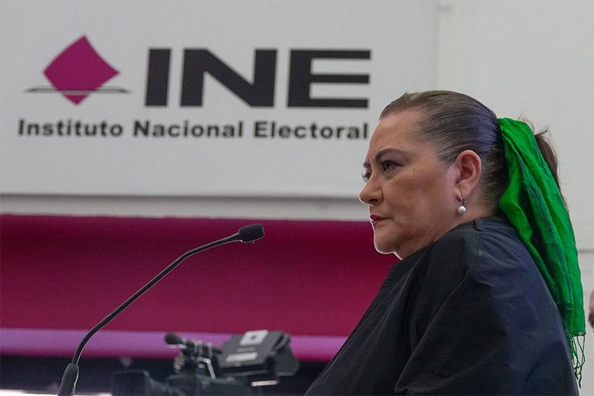 Mexico's elections chief Guadalupe Taddei stands in front of a sign reading "INE: Instituto Nacional Electoral"