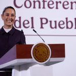 President Claudia Sheinbaum smiles from the podium during her morning press conference, or mañanera