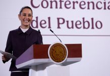 President Claudia Sheinbaum smiles from the podium during her morning press conference, or mañanera