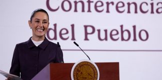 President Claudia Sheinbaum smiles from the podium during her morning press conference, or mañanera