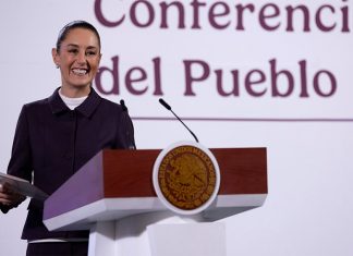 President Claudia Sheinbaum smiles from the podium during her morning press conference, or mañanera