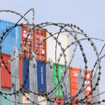 barbed wire in front of shipping containers