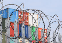 barbed wire in front of shipping containers