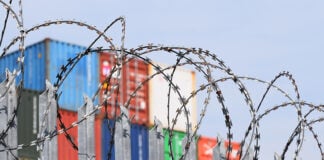 barbed wire in front of shipping containers