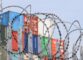 barbed wire in front of shipping containers