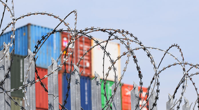 barbed wire in front of shipping containers