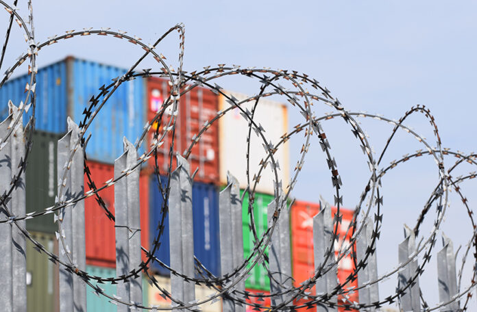 barbed wire in front of shipping containers