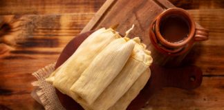 Tamales served on a plate with (possibly) champurrado.