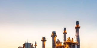 An energy plant lit up in the dawn