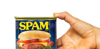 A hand holds a can of spam