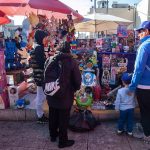 Adults and a child look at toys in an outdoor toy market in Mexico City, ahead of Kings' Day