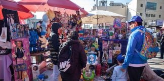 Adults and a child look at toys in an outdoor toy market in Mexico City, ahead of Kings' Day
