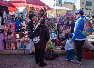 Adults and a child look at toys in an outdoor toy market in Mexico City, ahead of Kings' Day