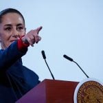 Mexican President Claudia Sheinbaum points to the crowd from her podium during her daily press conference