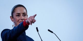 Mexican President Claudia Sheinbaum points to the crowd from her podium during her daily press conference