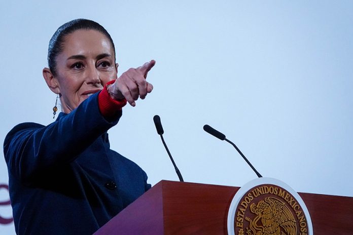 Mexican President Claudia Sheinbaum points to the crowd from her podium during her daily press conference