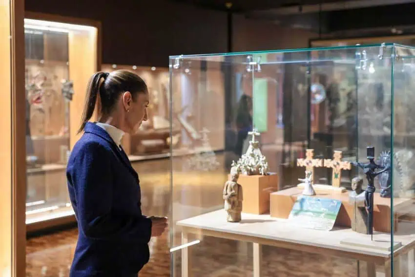 Mexico's President Claudia Sheinbaum examines Indigenous artifacts behind glass at the National Anthropology Museum