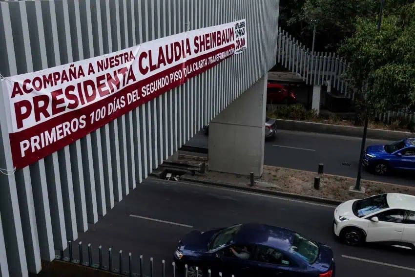 Banner in Spanish on a Mexico City highway bridge inviting the public to President Claudia Sheinbaum's upcoming 100 days state of the nation report.