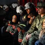 Mexican soldiers and firefighters in a military plane in uniform and firefighting gear awaiting takeoff to fight fires in Los Angeles.