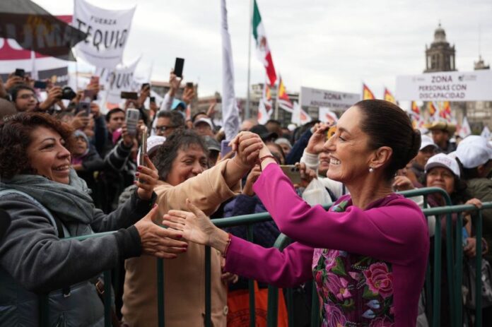 President Claudia Sheinbaum shakes hands with the crowd during her 100-day address in Mexico City