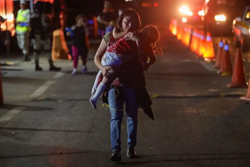 A migrant mother and child started walking north in the early hours of the day on Monday.