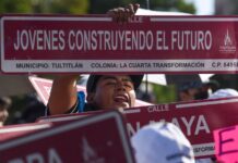 A women holding up a sign saying "young people building the future." Part of a Plan Mexico podcast.