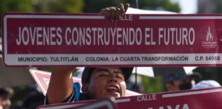 A women holding up a sign saying "young people building the future." Part of a Plan Mexico podcast.