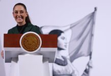 Mexico's President Claudia Sheinbaum smiling as she talks to reporters at the National Palace at a press conference