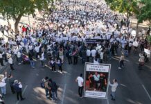 Hundreds of protesters in white can be seen gathered around a banner reading "Culiacán está en luto"