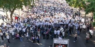 Hundreds of protesters in white can be seen gathered around a banner reading "Culiacán está en luto"