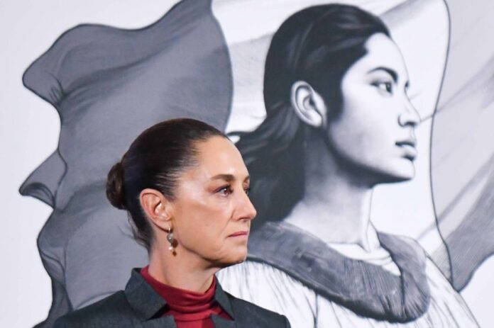 Side profile photo of Mexican President Claudia Sheinbaum at a press conference, standing in a parallel position to her admnistration's logo, a illustration in profile of a young Mexican Indigenous woman standing in front of the Mexican flag